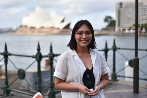 Girl with and award in front of the Sydney Opera House