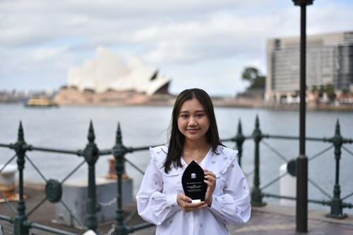 Girl with and award in front of the Sydney Opera House