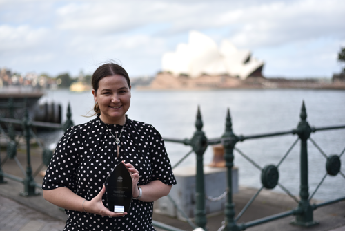 Girl with and award in front of the Sydney Opera House