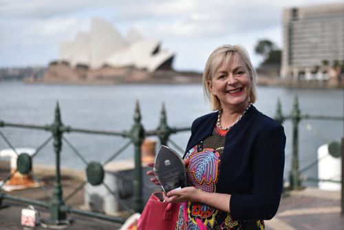 Female with and award in front of the Sydney Opera House